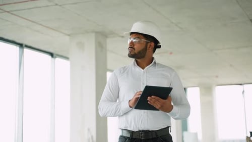 Indian Engineer Reviewing Construction Project Data with Tablet Onsite