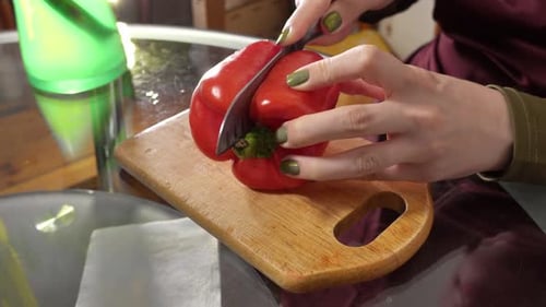 Hands Slicing Red Pepper on Cutting Board