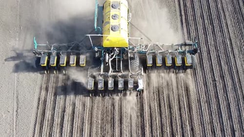 Tractor with yellow seeder working on the field in Ukraine OA Lexa