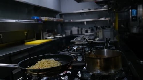 Close-up of a Restaurant Chef Cooking Food on Fire in the Restaurant Kitchen