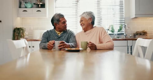 Senior Couple Enjoying Coffee and Laughing in Kitchen