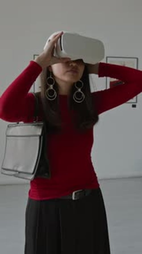 Asian Woman Putting On VR Headset at Digital Art Exhibition in Modern Gallery