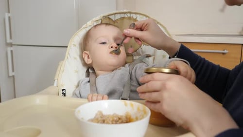 Baby Being Fed in High Chair at Home