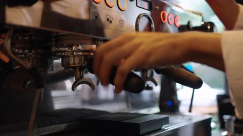4K Barista making hot coffee on coffee maker at coffee shop.