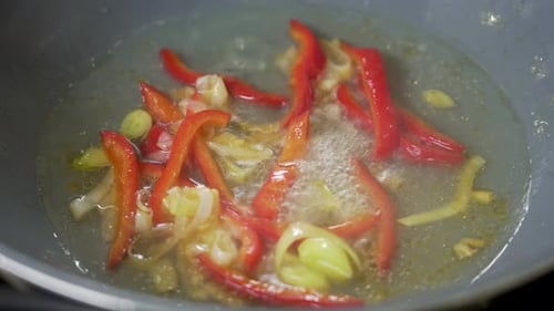 Mexendo vegetais enquanto cozinha a sopa Tom Yum em um wok