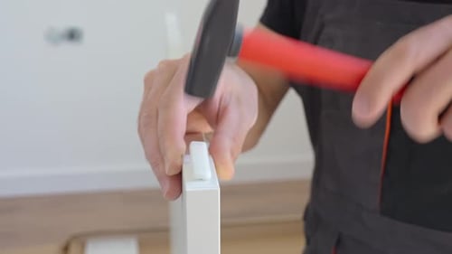 Male Carpenter Using Hammer While Assembling Furniture at Home