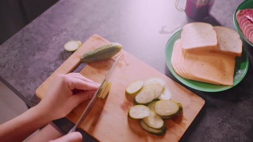 Woman Prepares Food: Slicing Pickles on Cutting Board
