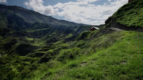 A Mountain Range with a Small Cabin on Top
