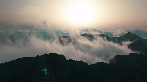 Hyperlapse of mist that is blown over the ridge during sunrise in the mountains.