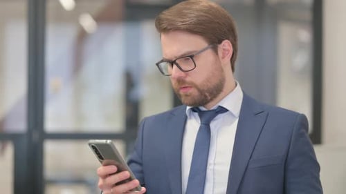 Businessman Using Smartphone in Modern Office