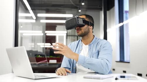 Young Man Uses VR Headset in Modern Office