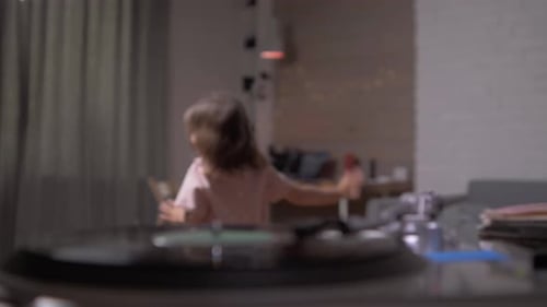 Little Girl Dancing at Home to the Sound of a Vintage Vinyl Record Player