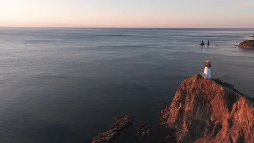 Lighthouse Perched on Cliff Overlooking Ocean