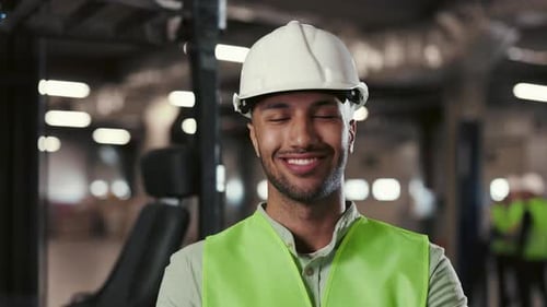 MultiEthnic Male Engineer Posing with Crossed Arms Standing in the Factory or Plant
