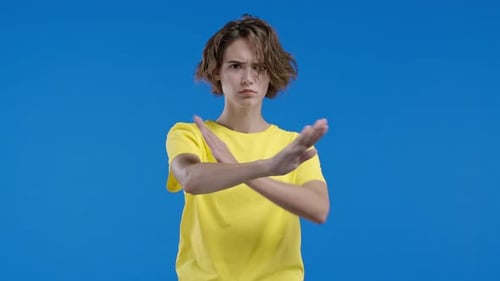 Woman Gesturing "Stop" Against Blue Background