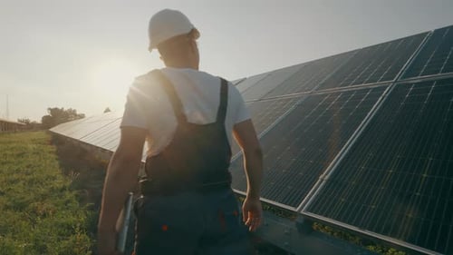An Engineer Inspecting Solar Panels While Walking Around the Station