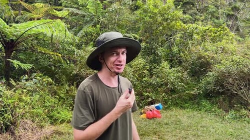 Man Talking in Tropical Forest with Ferns