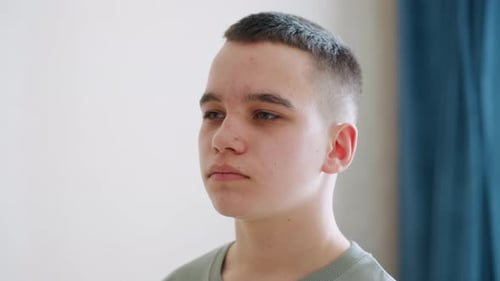 Confident Boy Standing Calmly in Daylight with Focused Expression
