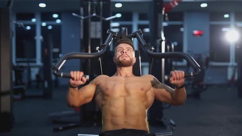Shirtless Man Working Out on Weight Machine