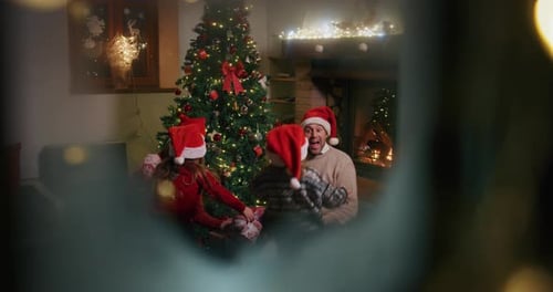 Slow motion of happy family having fun to celebrate Christmas holidays, opening presents view from