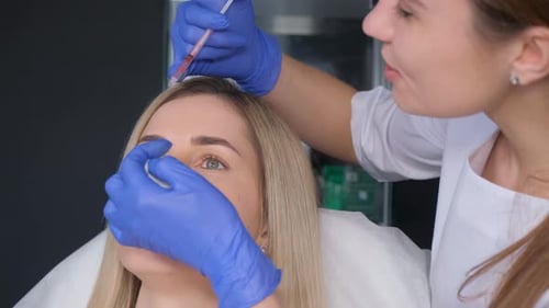 Woman receiving injection on forehead at clinic