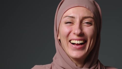 Muslim Woman Laughs Joyfully and Looks at the Camera