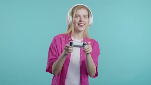 Young Woman Playing Video Game with Controller and Headphones
