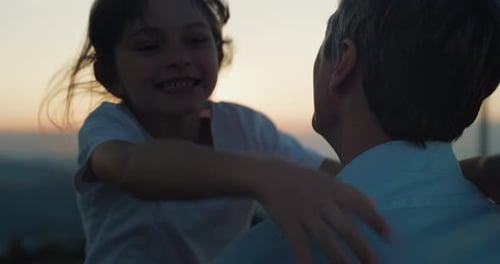 Portrait of Little Girl Running and Jumping to Hug her Father in an Open Green Field During Sunse