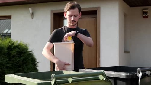 Man Sorts Recycling and Trash into Bins