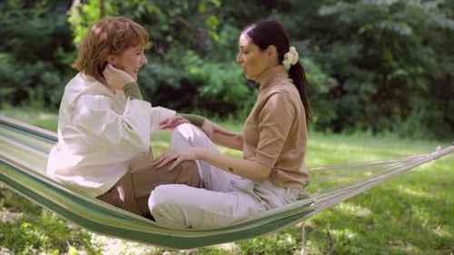 Young Women Relaxing in a Hammock Outdoors