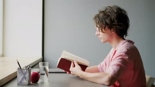 Young Man Writing in Notebook
