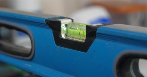 Close POV shot of a handyman slowly checking the horizon accuracy with a spirit level or bubble leve