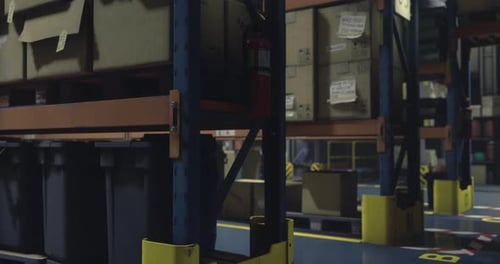 Un entrepôt spacieux comprend de hautes étagères métalliques remplies de boîtes en carton