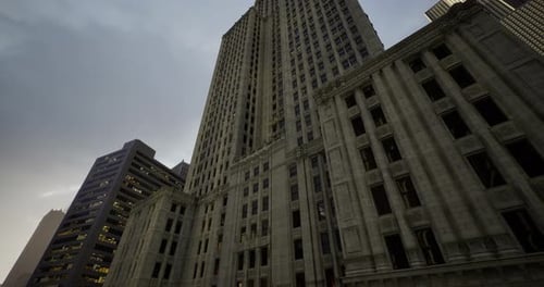 Edificios altos se ciernen bajo un cielo nublado en un entorno urbano durante el crepúsculo