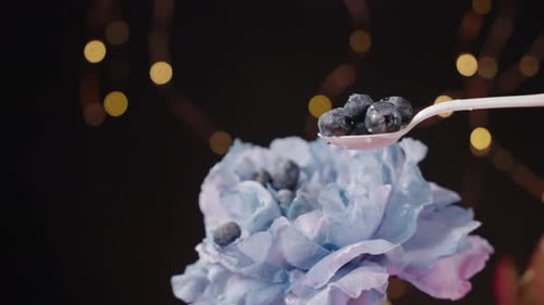 Blueberries Pouring over a Pastel Flower with Lights