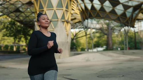 Woman Jogging Through a Park on a Sunny Day