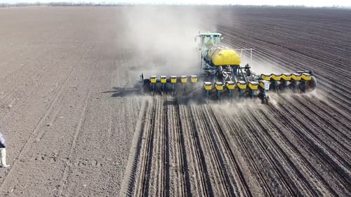 Tractor with yellow seeder working on the field in Ukraine OA Lexa
