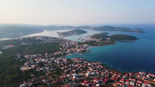 Aerial View of Coastal Town with Redroofed Houses and Blue Sea