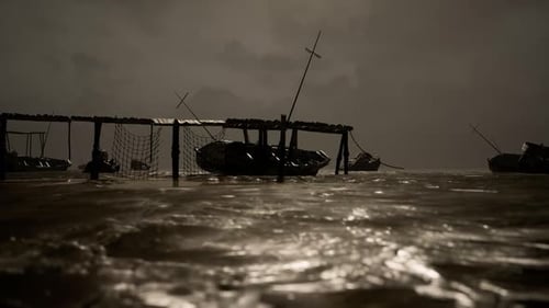 Dark Waters Reflect a Weathered Fishing Dock in Quiet Surroundings at Dusk