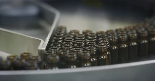 Gros plan de la production de médicaments dans des flacons de verrerie sur des lignes automatiques dans une usine pharmaceutique