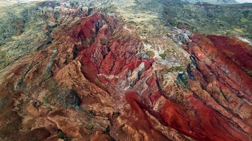 Drone Steep Rocky Cliff with Dominant Red Colors Erosion Marks Rough Stones