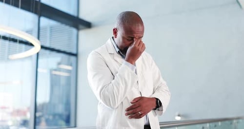 Doctor, healthcare and black man in hospital, headache and overwhelmed with stress