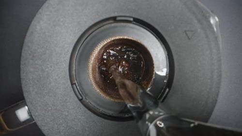 The Camera Descends Lower and Lower, and Boiling Water Is Poured for Brewing Tea Inside the Sieve.