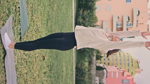 Woman Doing Yoga Stretch on Lawn