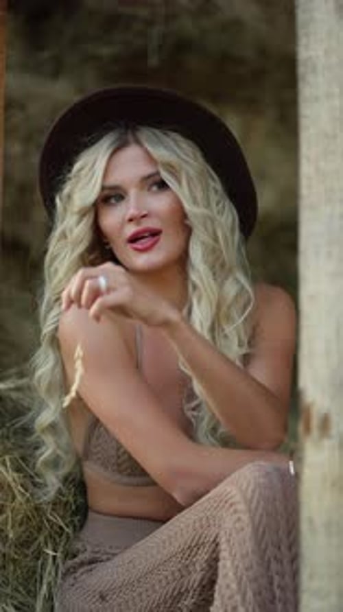 Blonde Woman Posing in Front of Hay