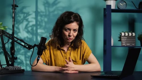 Woman Speaks into a Microphone at Her Desk