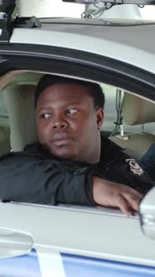 Young Adult in Police Uniform Sitting in Car