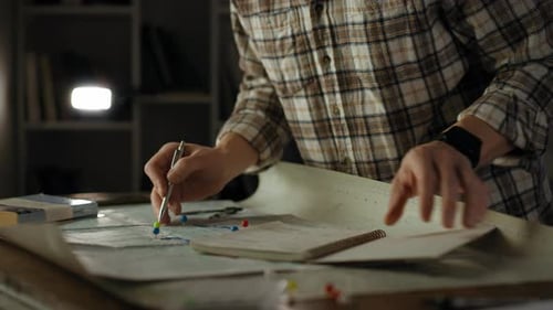 Adult Plans Route on Map at Night