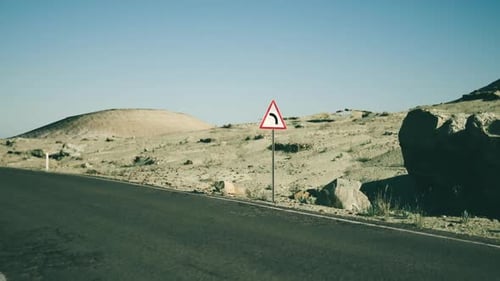 Curving Road Sign in the Vast Mongolian Landscape on a Clear Day