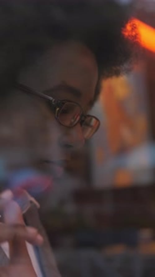 African Woman Taking Notes and Using Tablet at Cafe
